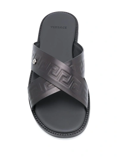 Shop Versace Embossed Greca Crossover Strap Sandals In Black