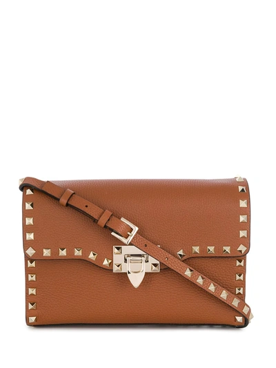 Shop Valentino Small Rockstud Crossbody Bag In Brown