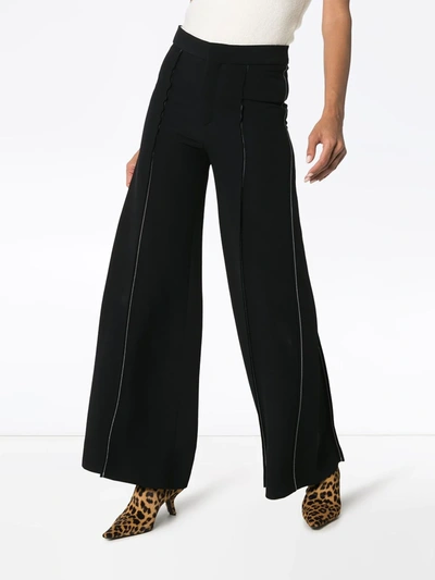 Shop Marni Contrast-stitch Flared Trousers In Black