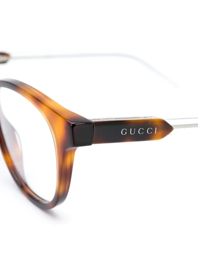Shop Gucci Oval Frame Glasses In Brown