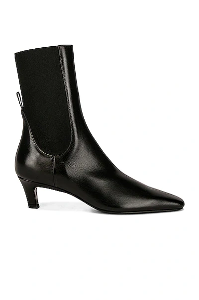 Shop Totême The Mid Heel Boot In Black