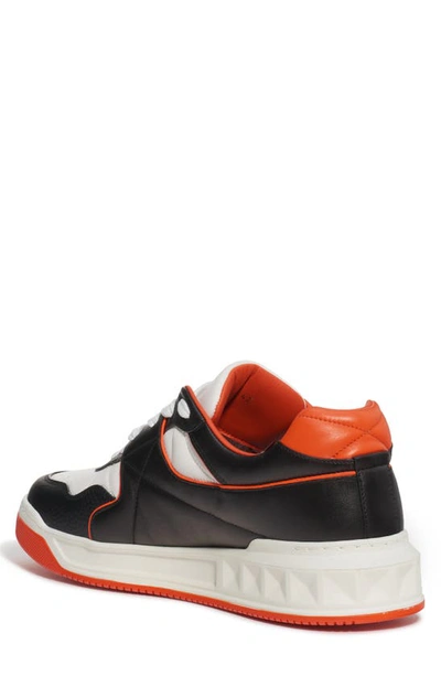 Shop Valentino Roman Stud Low Top Sneaker In Black/ White/ Orange