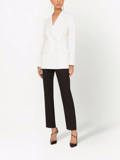 A $1,195 white peak-lapeled cotton jacket by Dolce & Gabbana tops