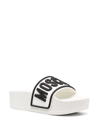 Shop Moschino Logo Embossed Platform Slides In White