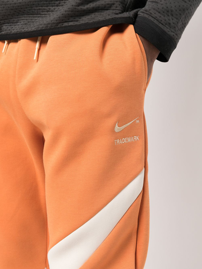 Nike Swoosh-print Fleece Track Pants In Orange