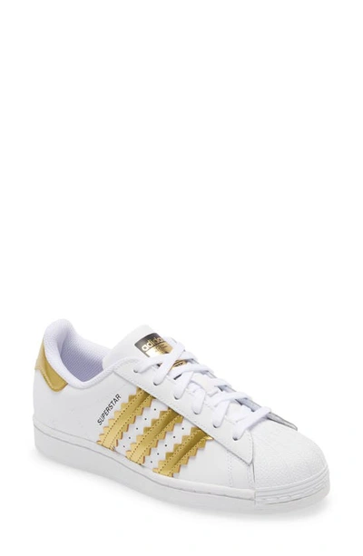 Shop Adidas Originals Superstar Sneaker In White/matte Gold/core Black