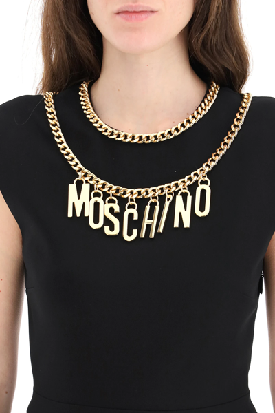 Shop Moschino Short Dress With Logo Lettering And Charm In Black,gold