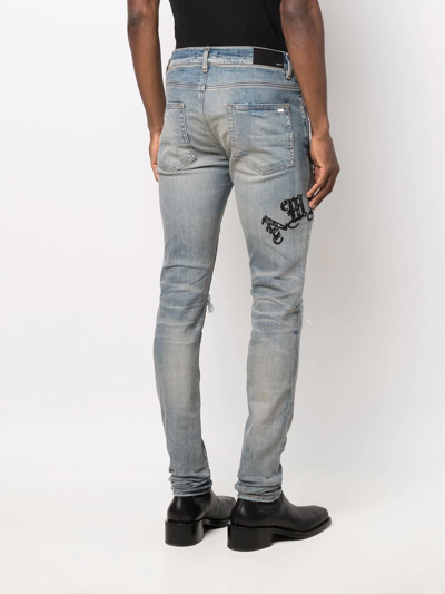 Shop Amiri Logo Distressed Skinny Jeans In Blue