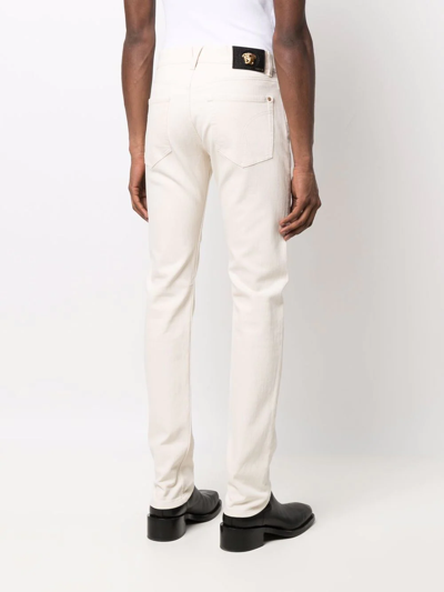 Shop Versace Skinny-cut Mid-rise Jeans In Nude