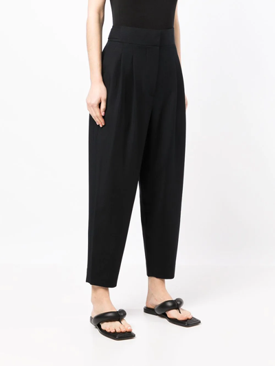 Shop Goodious Pleated Tapered-leg Trousers In Schwarz