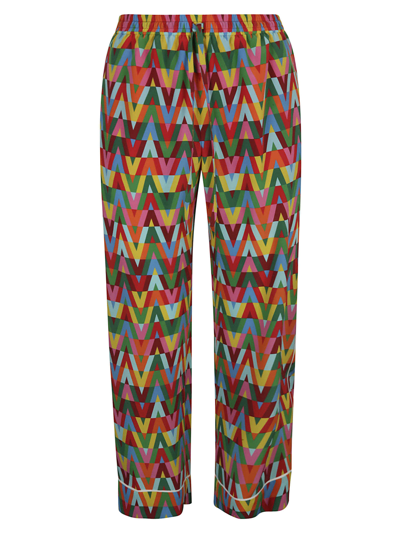 Shop Valentino All-over Logo Print Trousers In Multicolor