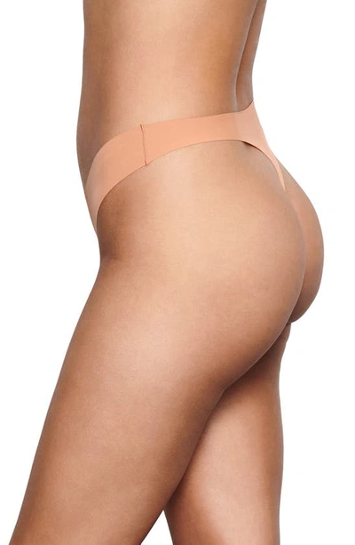 Shop Skims Naked Mid Rise Thong In Ochre