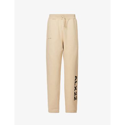 Shop Alyx Logo-print Relaxed-fit Tapered Cotton-jersey Jogging Bottoms In Natural Dark