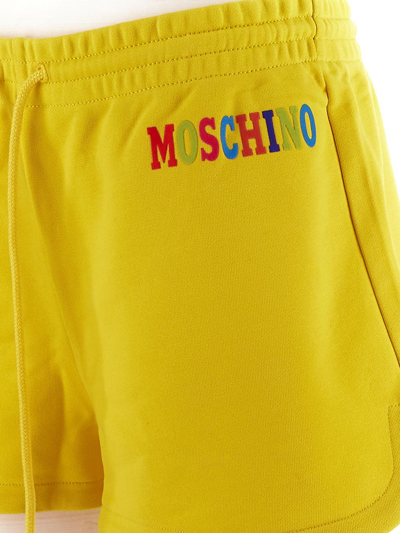 Shop Moschino Embossed Multicolor Logo Shorts In Yellow