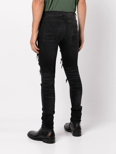 Shop Amiri Ripped Skinny Jeans In Schwarz