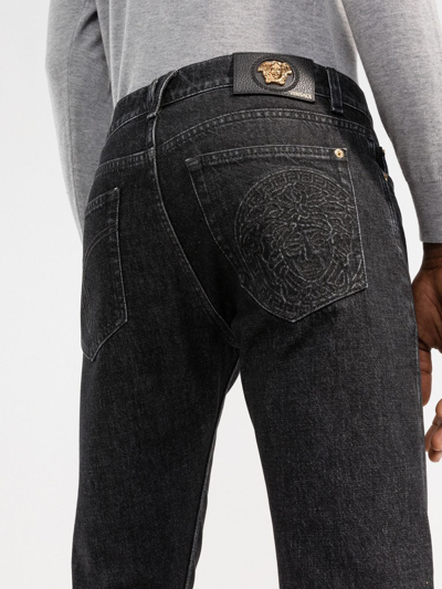 Shop Versace Tapered Denim Jeans In Schwarz