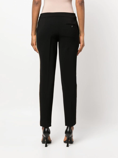 Shop Moschino Tapered Side-stripe Trousers In Schwarz