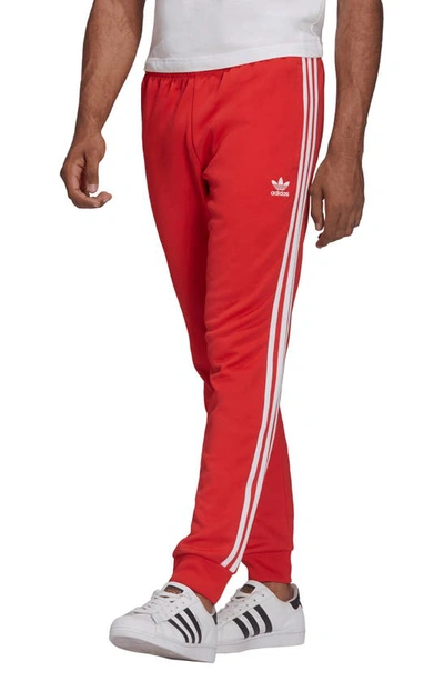 Shop Adidas Originals Adicolor Classics Primeblue Sst Track Pants In Vivid Red