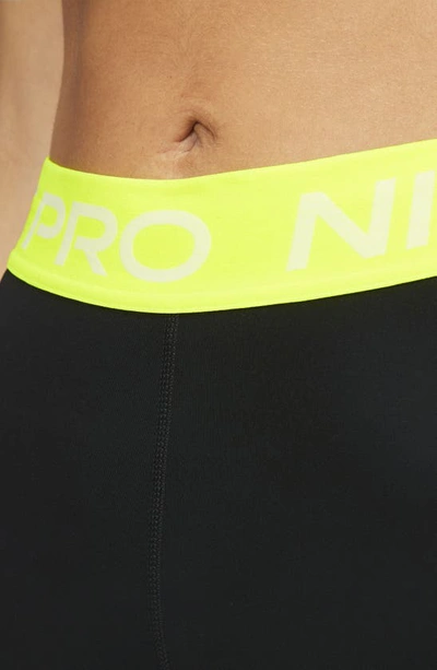 Shop Nike Pro Mid Rise Leggings In Black/ Volt/ White