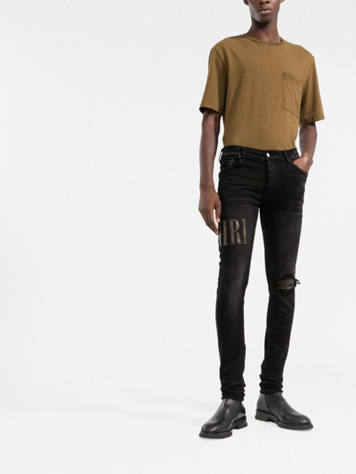 Amiri Old English Logo Distressed Denim Jeans In Black