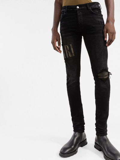 Amiri Old English Logo Distressed Denim Jeans In Black