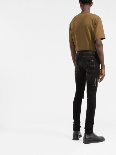 Amiri Old English Logo Distressed Denim Jeans In Black