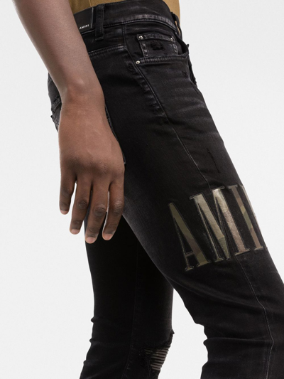Amiri Old English Logo Distressed Denim Jeans In Black
