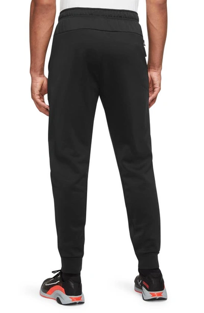 Shop Nike Therma-fit Tapered Training Pants In Black/ Black/ White