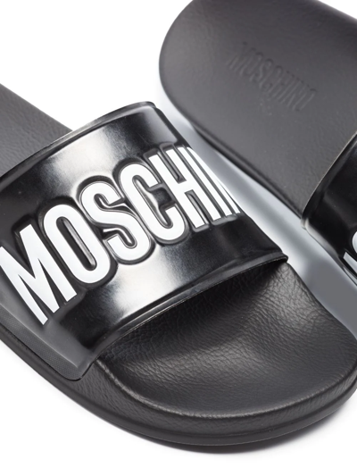 Shop Moschino Debossed-logo Pool Slides In Schwarz