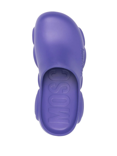 Shop Moschino Logo Embossed Mules In Purple