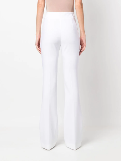 Shop Genny High-waisted Flared Trousers In White
