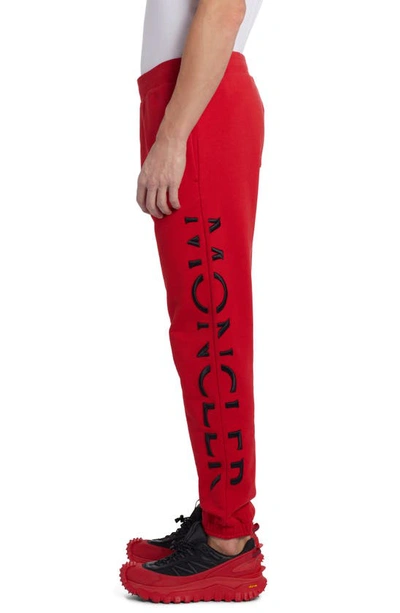 Shop Moncler Embroidered Strike Out Cotton Sweatpants In Red