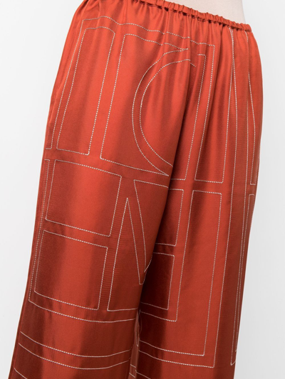 Shop Totême Monogram Logo-embroidered Trousers In Orange