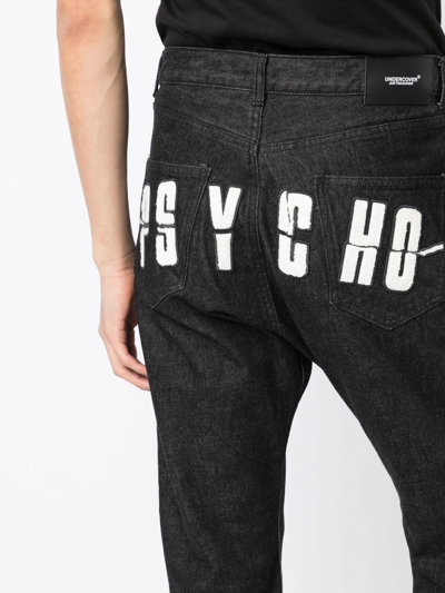 Shop Undercover X Psycho Logo-appliqué Jeans In Black