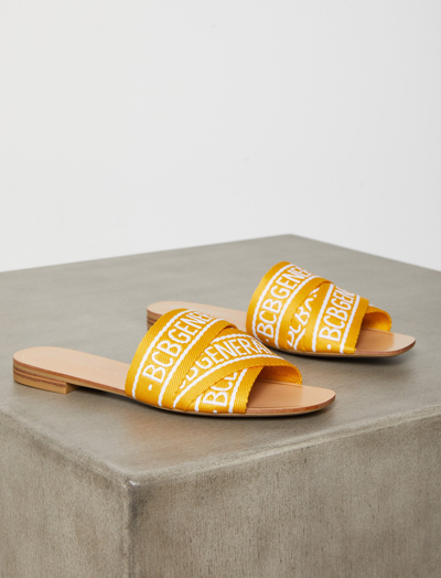 Shop Bcbgeneration Kala Logo Flat Sandal In Golden Yellow / Bright White