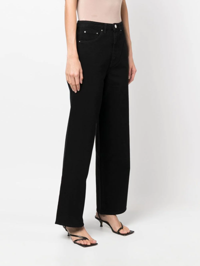 Shop Totême High-waisted Flared Jeans In Black