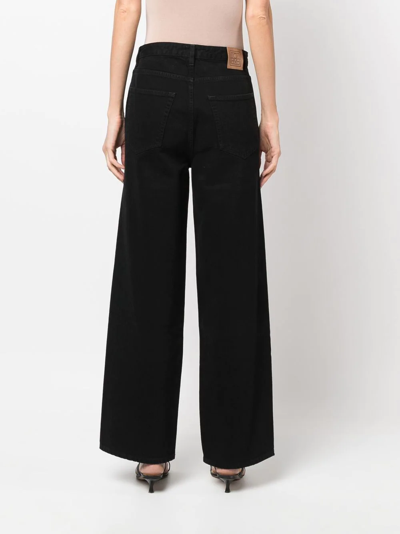 Shop Totême High-waisted Flared Jeans In Black