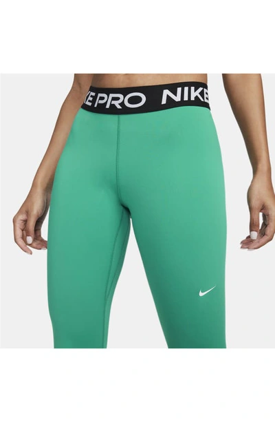 Shop Nike Pro Mid Rise Leggings In Neptune Green/ Black/ White