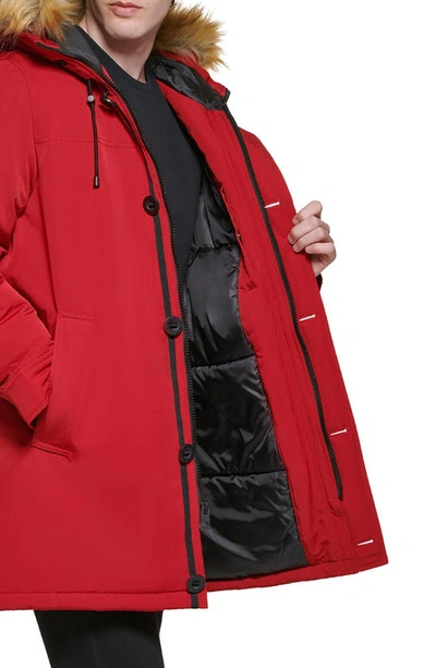 Shop Guess Faux Fur Trim Hooded Parka Jacket In Red