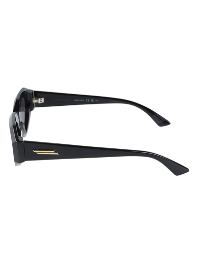 Shop Bottega Veneta Oval Frame Sunglasses In Black/grey