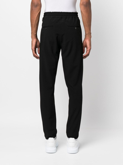 Shop John Richmond Horesbit-detail Tapered Trousers In Schwarz