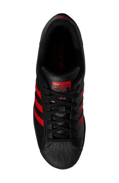 Shop Adidas Originals Superstar Sneaker In Black/ Red