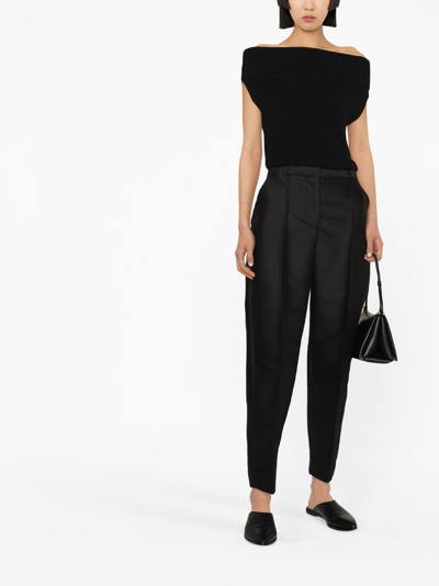 Shop Totême Pressed-crease Tapered Trousers In Black