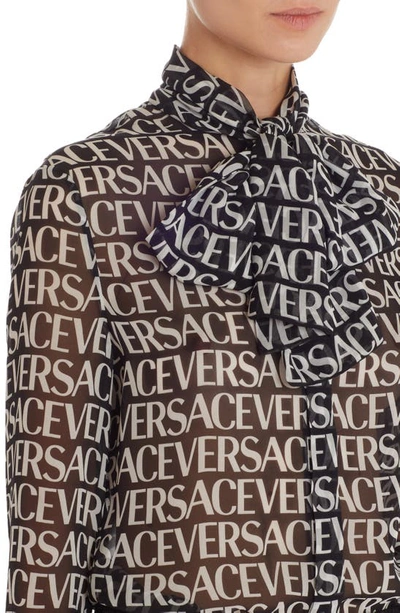 Shop Versace Logo Print Semisheer Tie Neck Silk Blouse In Black/ White
