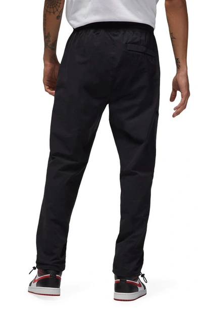 Shop Jordan Woven Stretch Nylon Pants In Black/ White