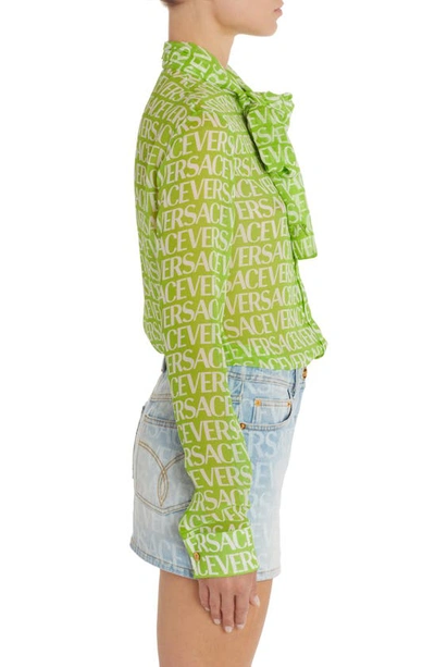 Shop Versace Logo Print Semisheer Tie Neck Silk Blouse In Green/ White