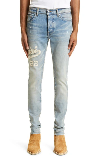 Shop Amiri Varsity Logo Distressed Stretch Denim Skinny Jeans In Clay Indigo