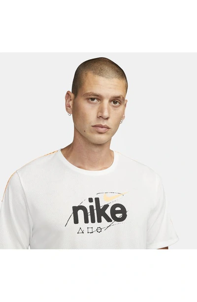 Shop Nike Miler Dri-fit Running Logo Graphic Tee In Summit White/ Peach Cream
