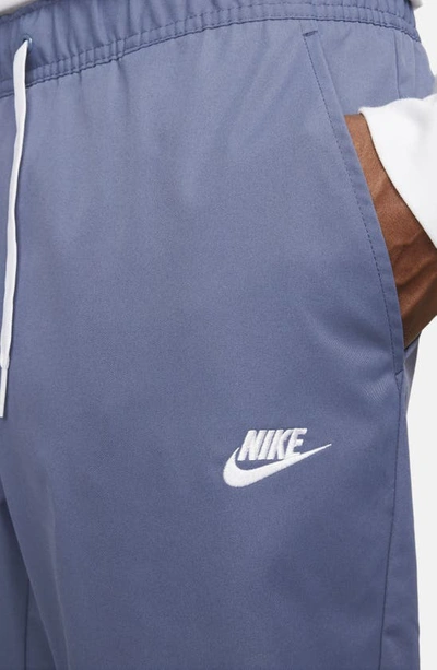 Shop Nike Woven Tapered Leg Pants In Diffused Blue/ White