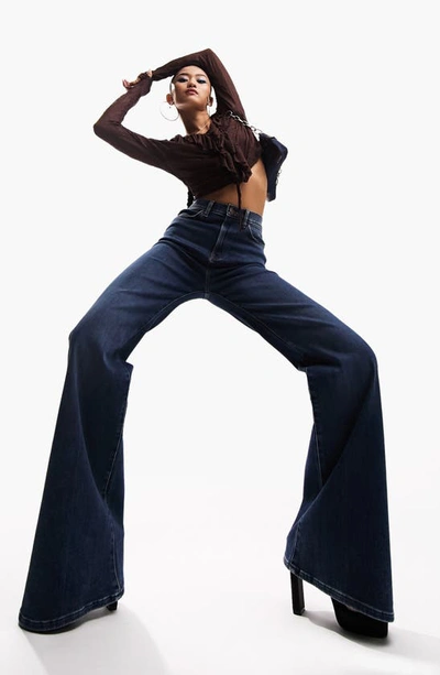 Shop Asos Design '70s Power Stretch High Waist Flare Jeans In Medium Blue